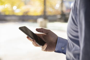 Businessman's hand using mobile phone - IFRF00196