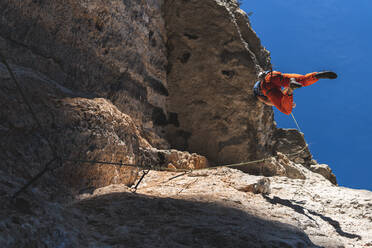 Active male athlete climbing rocky mountain - JAQF00021