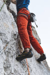 Sportsman climbing rocky mountain - JAQF00023