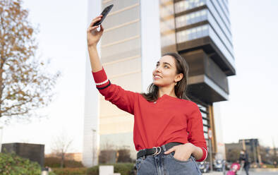 Junge Frau nimmt Selfie auf Smartphone in der Stadt - JCCMF00230