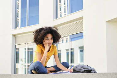 Studentin studiert sitzend auf dem Universitätscampus - AODF00021