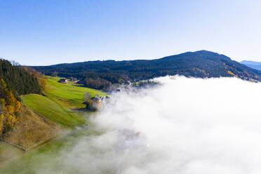 Drohnenansicht eines in dichten Nebel gehüllten Bergtals - WWF05737
