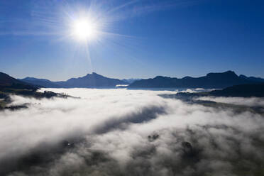 Drone view of Drachenwand and Schafberg mountains protruding from sea of thick fog - WWF05739