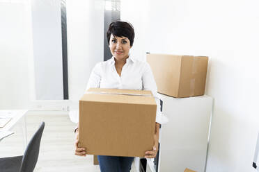 Portrait of businesswoman organizing office before relocation - GIOF10151