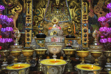 Golden decorative elements in Buddhist shrine with burning flames in praying holy place in China - ADSF19249