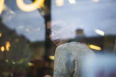 Seriöse, intelligente Frau in Freizeitkleidung und mit Brille steht in einem gemütlichen Café und schaut in die Kamera - ADSF19329