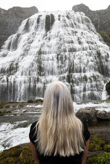 Frau mit Blick auf den Dynjandi-Wasserfall in den Westfjorden, Island - NEKF00062