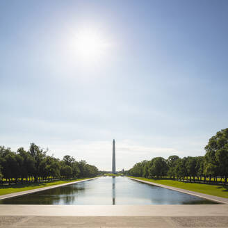 USA, Washington DC, Sonne scheint über dem Lincoln Memorial Reflecting Pool mit dem Washington Monument im Hintergrund - AHF00217