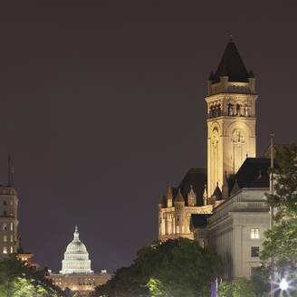 USA, Washington DC, Turm des alten Postamts bei Nacht mit dem Kapitol der Vereinigten Staaten im Hintergrund - AHF00248