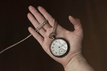Hand of woman holding antique pocket watch - FCF01943