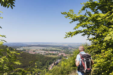 Deutschland, Thüringen, Bad Tabarz, Älterer Wanderer bewundert die Aussicht auf die Stadt im Thüringer Wald im Frühling - GWF06799