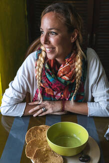 Lächelnde Frau träumt beim mexikanischen Essen im Restaurant - JMPF00749