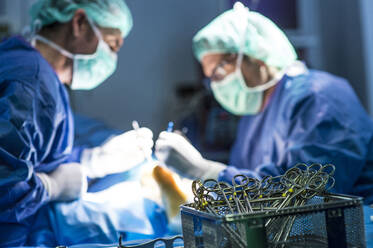 Männliche Chirurgen führen in der Notaufnahme eines Krankenhauses eine Operation mit einer Schere durch - JCMF01717