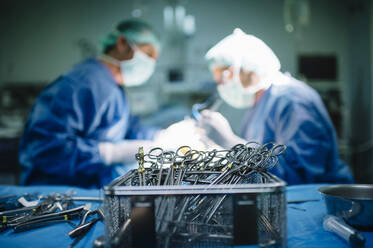 Männliche orthopädische Chirurgen, die in der Notaufnahme eines Krankenhauses operieren - JCMF01719
