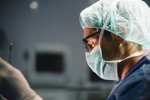 Männlicher orthopädischer Chirurg, der eine Operation in der Notaufnahme durchführt - JCMF01728