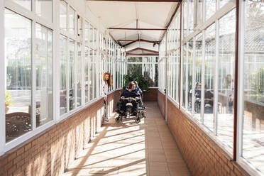 Behinderter Mann und Frau im Rollstuhl mit Krankenschwester im Rehabilitationszentrum - LJF01997