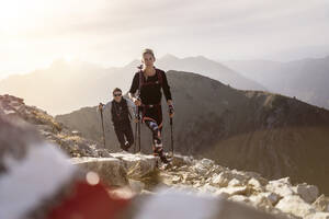 Sportler und Frau mit Wanderstock und Rucksack auf dem Bergpfad des Bschiesser in Tirol, Österreich - MALF00332