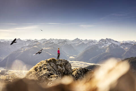 Sportlerin mit Blick auf die Aussicht, während sie auf dem Aggenstein in Bayern, Deutschland, steht, lizenzfreies Stockfoto