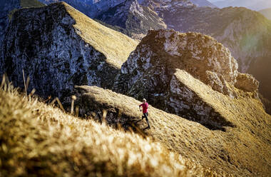 Sportswoman exercising while running on Aggenstein mountain at Bavaria, Germany - MALF00338