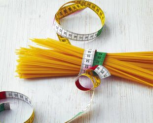 Rohe Spaghetti mit Maßband umwickelt - PPXF00324
