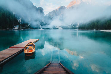 From above wooden quay on amazing scenery of lake with turquoise water in mountains on foggy day - ADSF19352