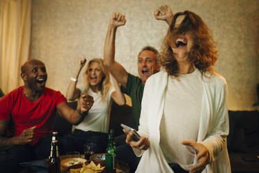 Cheerful couples enjoying sports in living room at home - MASF21011