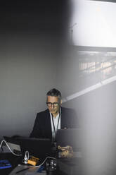 Männlicher IT-Fachmann arbeitet an einem Laptop in einem kreativen Büro - MASF21016