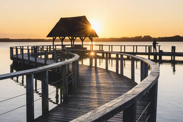 Deutschland, Schleswig-Holstein, Hemmelsdorf, Sonnenaufgang über der Seebrücke am Hemmelsdorfer See - KEBF01712