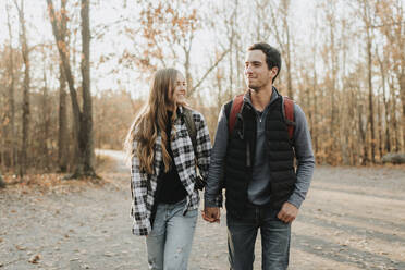 Young couple holding hands during autumn hike - SMSF00469