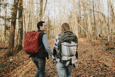 Junges Paar hält sich bei einer Herbstwanderung an den Händen - SMSF00477