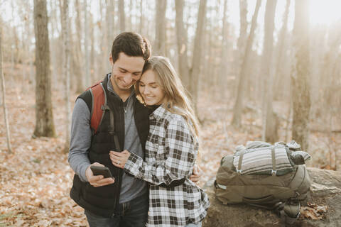 Junges Paar nimmt Smartphone-Selfie während Herbstwanderung, lizenzfreies Stockfoto