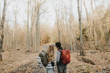 Young couple standing in forest during autumn hike - SMSF00483