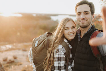 Porträt eines jungen Paares, das während einer Herbstwanderung zusammen posiert - SMSF00516