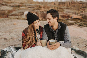 Young couple camping together with mugs in hands - SMSF00528