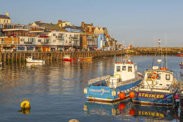 View of harbour boats and harbourside shops in Bridlington Harbour at sunset, Bridlington, East Yorkshire, England, United Kingdom, Europe - RHPLF18509