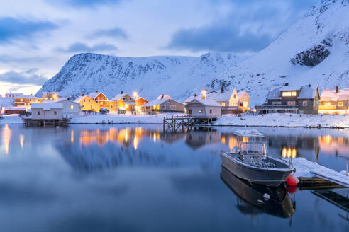 Beleuchtetes Dorf Sorvaer spiegelt sich in der kalten See während der Winterdämmerung, Insel Soroya, Troms og Finnmark, Nordnorwegen, Skandinavien, Europa - RHPLF18547