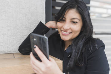 Schöne Frau nimmt Selfie auf Handy, während lehnt an der Wand - DSIF00255
