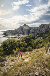 Woman hiking in landscape near sea - MSUF00396