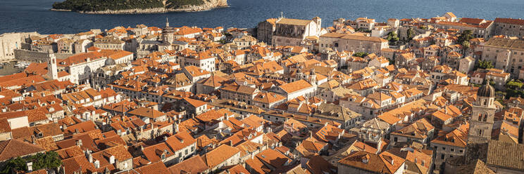 Kroatien, Dubrovnik, Altstadtgebäude mit orangefarbenen Dächern und Meer im Hintergrund - MSUF00411