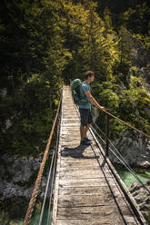 Man standing on footbridge in landscape - MSUF00454