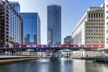 Dockland Light Railway (DLR)-Zug bei der Überquerung des Middle Dock in Canary Wharf, Docklands, London, England, Vereinigtes Königreich, Europa - RHPLF18572