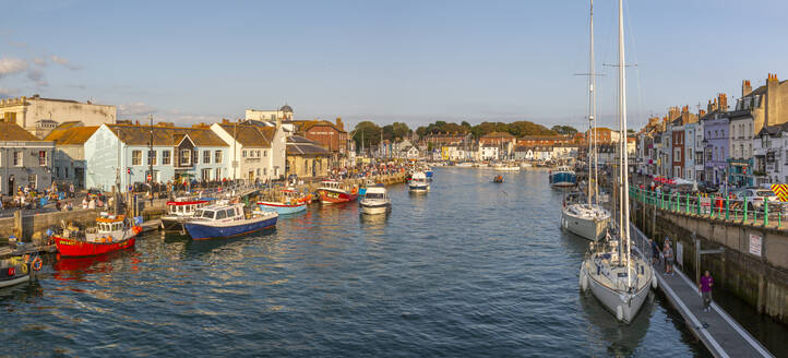 Blick auf Boote im Alten Hafen und Häuser am Kai bei Sonnenuntergang, Weymouth, Dorset, England, Vereinigtes Königreich, Europa - RHPLF18623