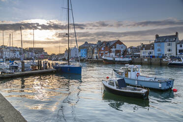 View of boats in the Old Harbour and quayside houses at sunset, Weymouth, Dorset, England, United Kingdom, Europe - RHPLF18625