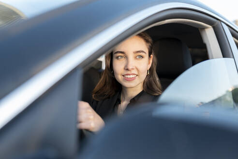 Geschäftsfrau lächelnd beim Autofahren - JCCMF00291