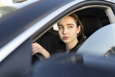 Businesswoman looking away while driving car - JCCMF00297