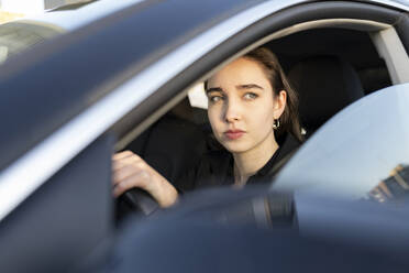 Geschäftsfrau schaut beim Autofahren weg - JCCMF00297