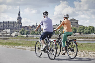 Tourist couple riding electric bicycle at Semper Opera House, Dresden, Germany - RORF02565