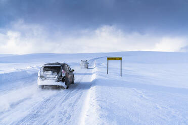 Geländewagen auf der vereisten Straße Richtung Nordkapp im tiefen Schnee, Troms og Finnmark, Nordnorwegen, Skandinavien, Europa - RHPLF18780