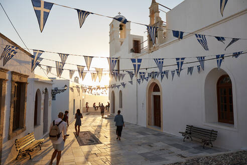 Sonnenuntergang in Plaka, dem Hauptort der Insel Milos, mit griechisch-orthodoxer Festtagsdekoration auf dem Kirchenplatz mit Kieselsteinmosaik, Plaka, Milos, Kykladen, Griechische Inseln, Griechenland, Europa - RHPLF18865