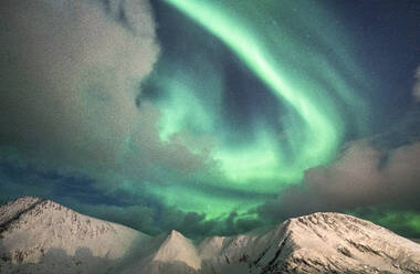 Nordlicht (Aurora Borealis) über schneebedeckten Bergspitzen, Sorvaer, Insel Soroya, Hasvik, Troms og Finnmark, Norwegen, Skandinavien, Europa - RHPLF18968